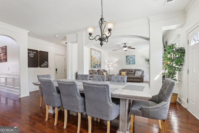 dining space featuring visible vents, arched walkways, dark wood finished floors, and ornamental molding