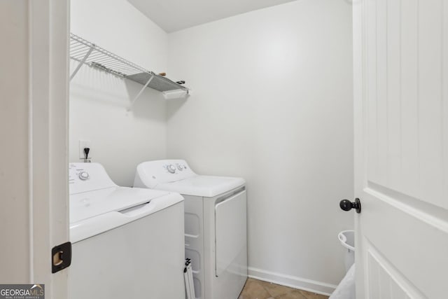 laundry area featuring light tile patterned floors, laundry area, washing machine and clothes dryer, and baseboards