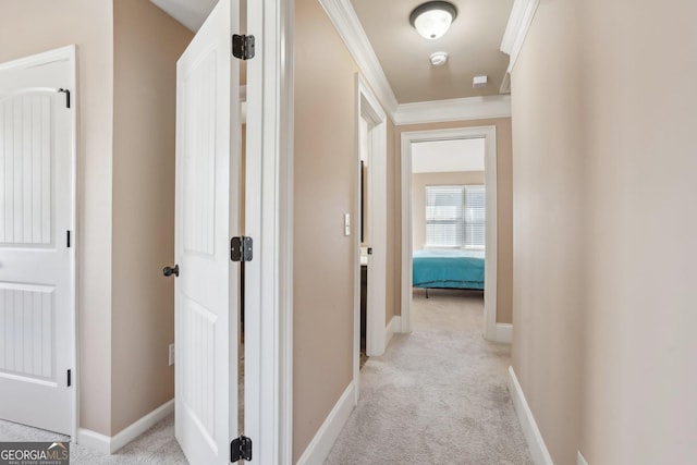 corridor featuring light carpet, baseboards, and crown molding