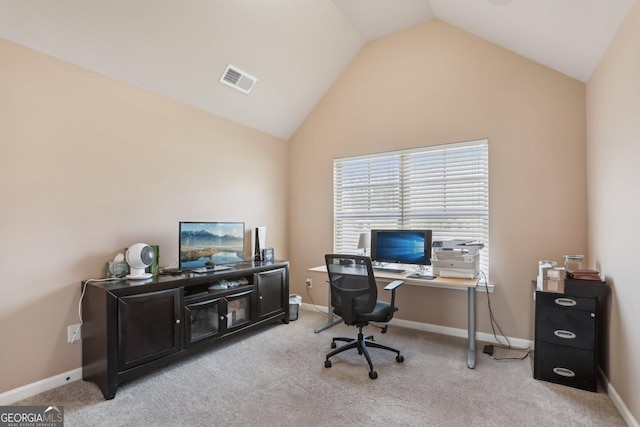 office area with light carpet, visible vents, and vaulted ceiling