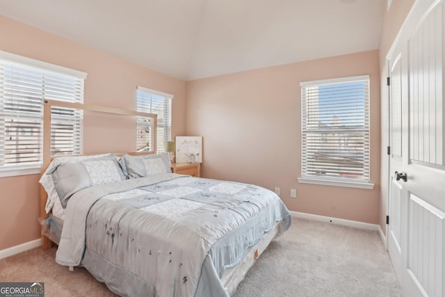 bedroom featuring baseboards, lofted ceiling, and light colored carpet