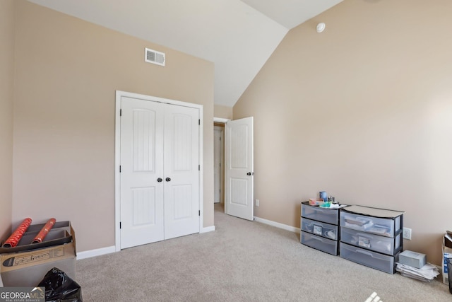 interior space with lofted ceiling, baseboards, visible vents, and light colored carpet