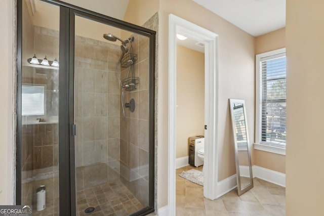 full bath with a stall shower, plenty of natural light, baseboards, and tile patterned floors