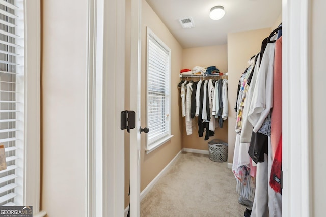 walk in closet featuring light carpet and visible vents