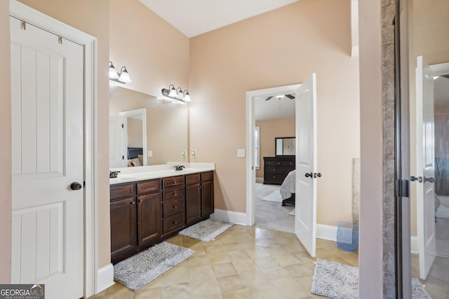 ensuite bathroom featuring ensuite bathroom, double vanity, a sink, and baseboards