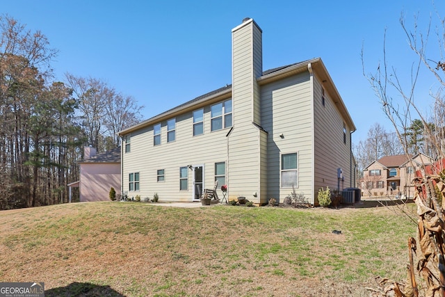 rear view of house with central AC, a lawn, and a chimney