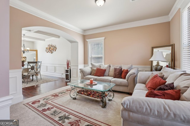 living area featuring arched walkways, coffered ceiling, wainscoting, beam ceiling, and dark wood finished floors