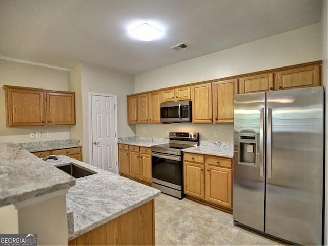 kitchen featuring a sink, visible vents, appliances with stainless steel finishes, light stone countertops, and brown cabinetry