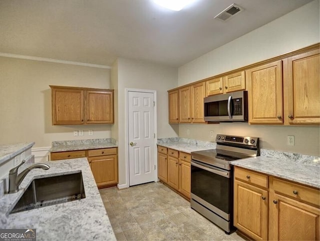 kitchen featuring light stone countertops, visible vents, stainless steel appliances, and a sink