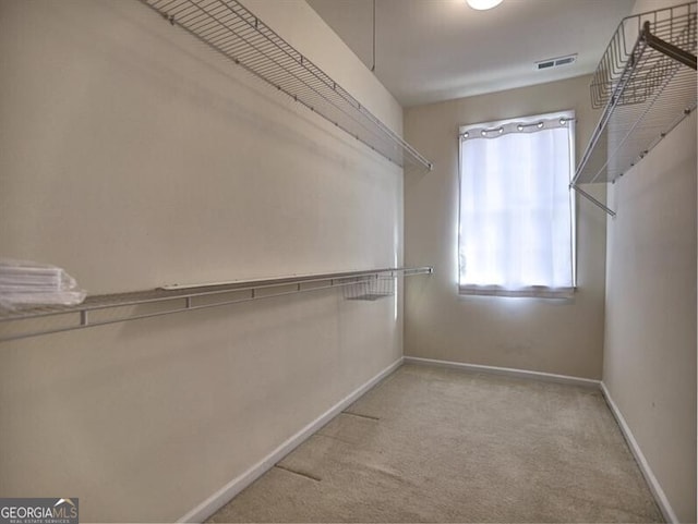 walk in closet with light carpet and visible vents