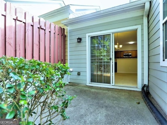 property entrance with fence and a patio