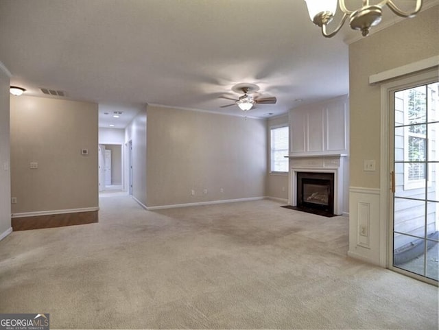 unfurnished living room featuring light colored carpet, visible vents, a fireplace with flush hearth, baseboards, and ceiling fan with notable chandelier