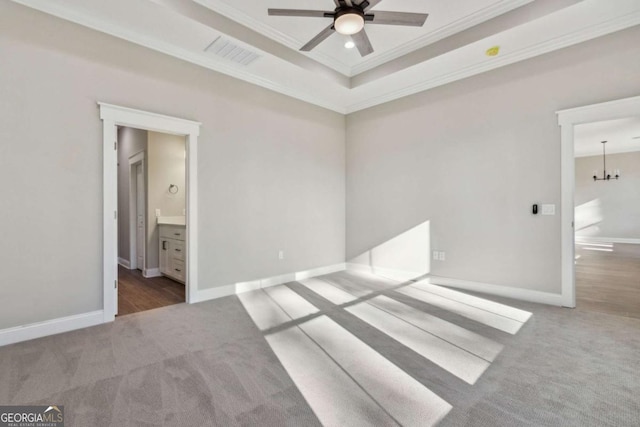 unfurnished bedroom with carpet floors, baseboards, visible vents, and a tray ceiling