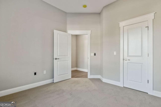 unfurnished bedroom with light carpet and baseboards