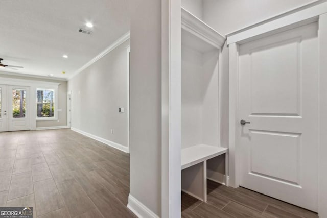 mudroom featuring ornamental molding, wood finish floors, visible vents, and baseboards