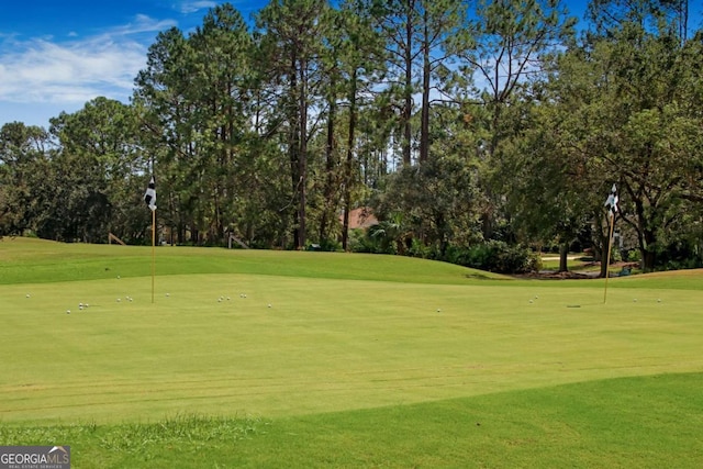 view of home's community featuring golf course view and a lawn