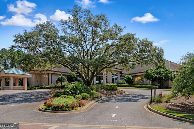 view of front of home featuring a gazebo, curved driveway, and stucco siding