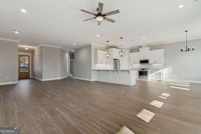 unfurnished living room with ceiling fan with notable chandelier, recessed lighting, wood finished floors, and baseboards