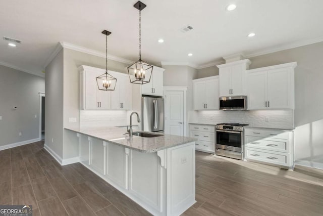 kitchen featuring stainless steel appliances, light stone countertops, white cabinetry, and decorative light fixtures