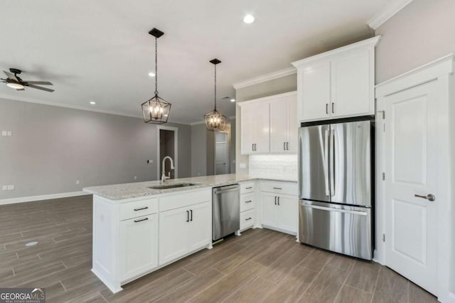 kitchen with stainless steel appliances, a peninsula, a sink, white cabinetry, and open floor plan