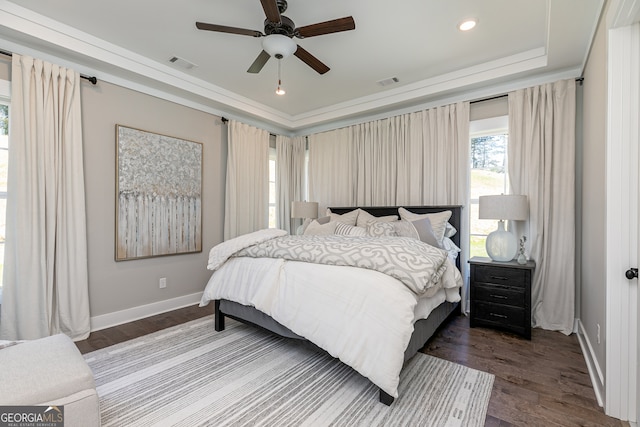 bedroom featuring baseboards, visible vents, a raised ceiling, and dark wood finished floors