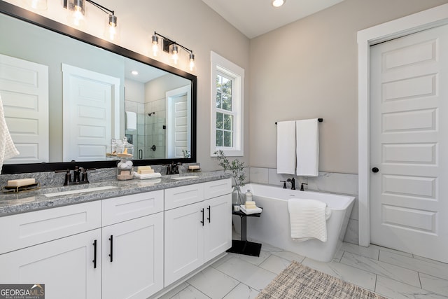 bathroom with marble finish floor, a sink, and a stall shower