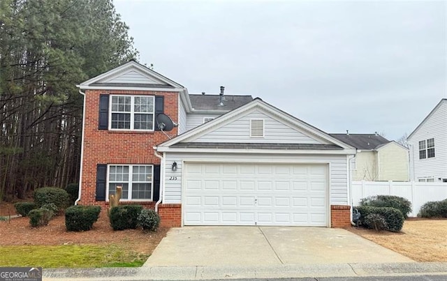 traditional-style house featuring a garage, concrete driveway, brick siding, and fence