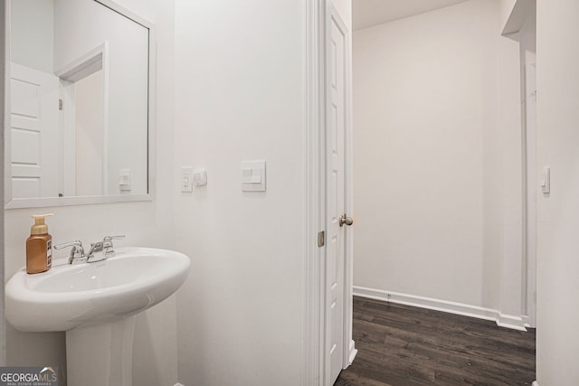 bathroom with a sink, baseboards, and wood finished floors