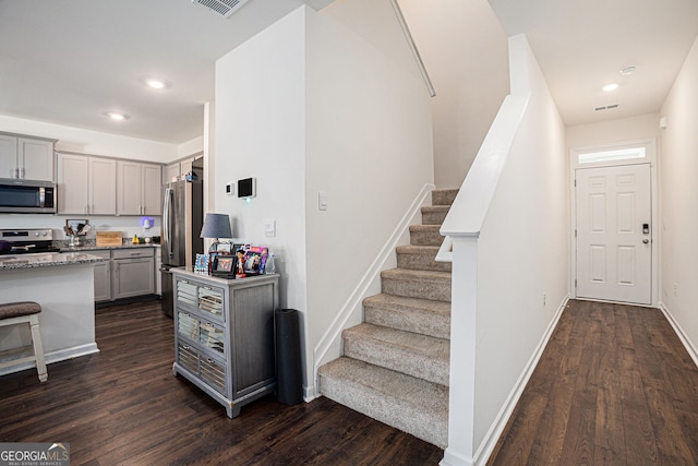 staircase featuring baseboards, wood finished floors, and recessed lighting