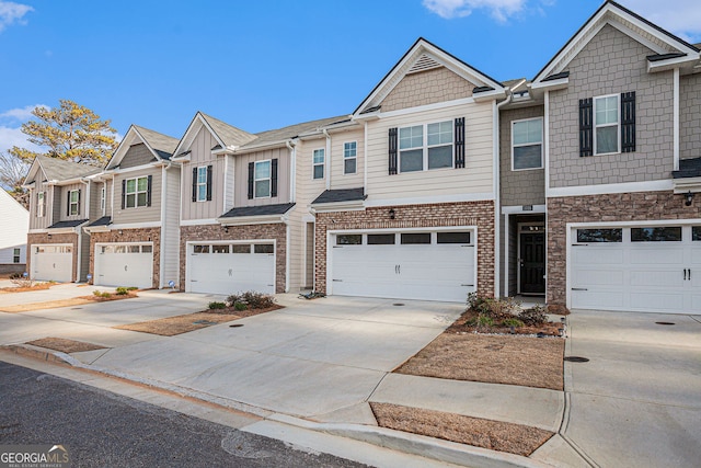 townhome / multi-family property with driveway, an attached garage, and a residential view