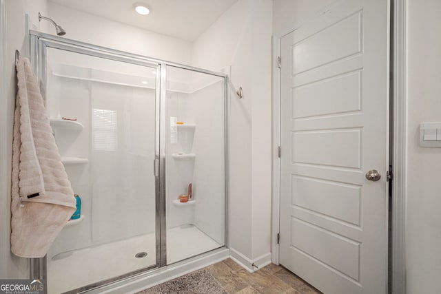 bathroom featuring a shower stall and baseboards