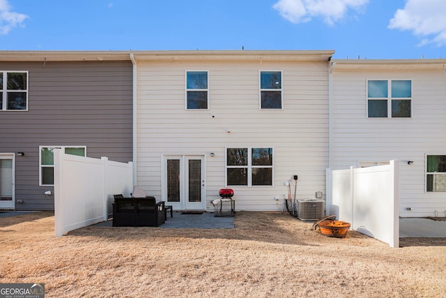 rear view of house featuring a patio area, central AC, and fence