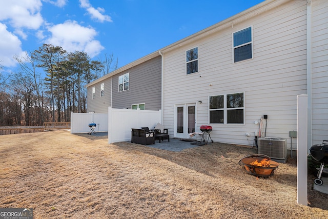 back of house with fence, a fire pit, and central AC unit