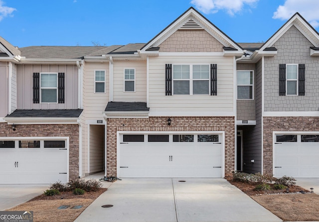 view of property featuring a shingled roof, brick siding, driveway, and an attached garage