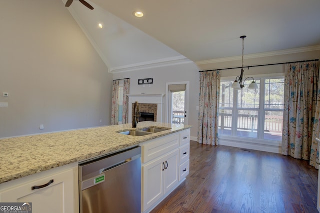 kitchen with light stone counters, stainless steel dishwasher, white cabinetry, pendant lighting, and a sink