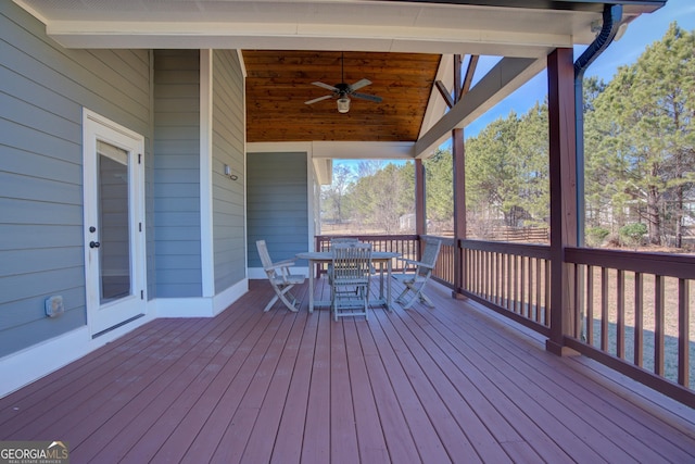 wooden terrace with outdoor dining space and ceiling fan