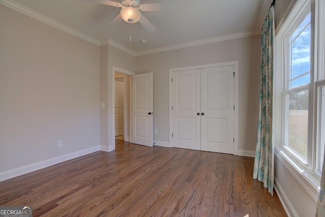 unfurnished bedroom with dark wood-style floors, ornamental molding, and baseboards