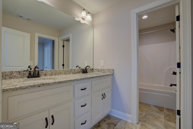 bathroom featuring double vanity, baseboards, visible vents, and a sink