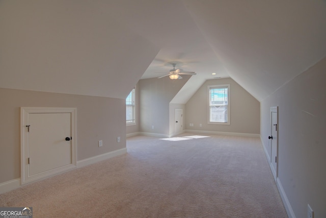 additional living space featuring vaulted ceiling, baseboards, and light colored carpet