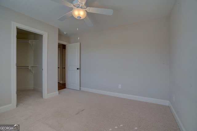 unfurnished bedroom with a closet, light carpet, ceiling fan, and baseboards