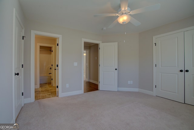 unfurnished bedroom featuring light carpet, ceiling fan, baseboards, and a closet