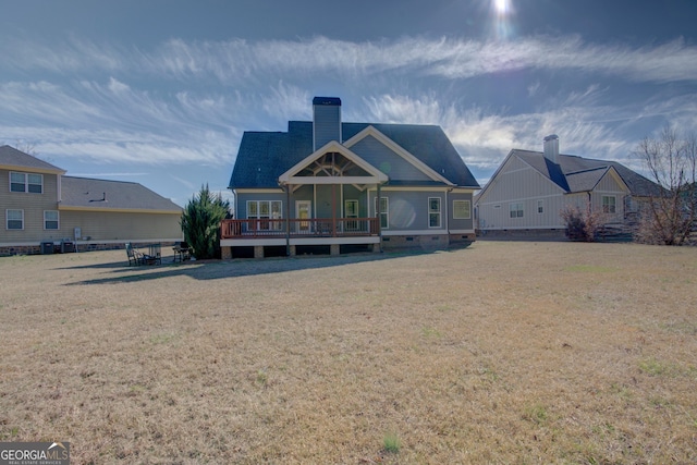 back of house with a lawn and a chimney