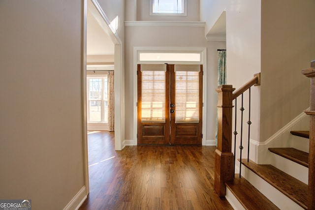 foyer featuring dark wood-style floors, french doors, a towering ceiling, stairway, and baseboards