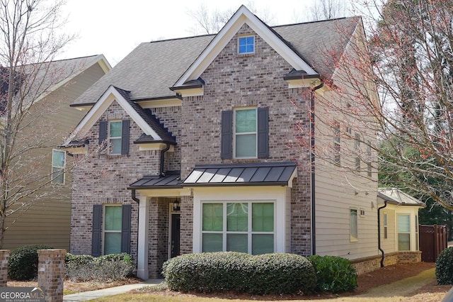 view of front of property featuring a standing seam roof, roof with shingles, metal roof, and brick siding