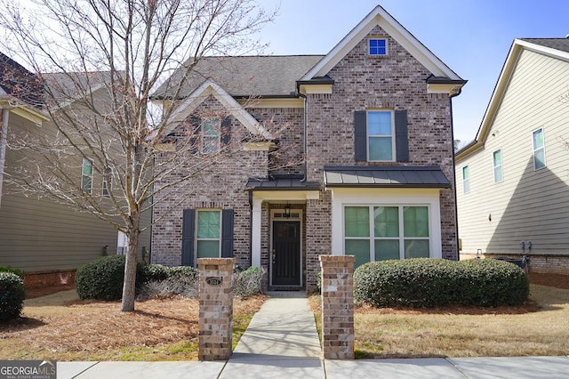 view of front of house featuring a standing seam roof, brick siding, and metal roof