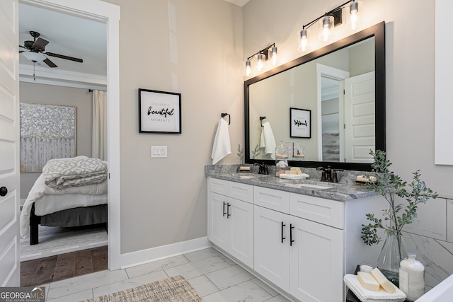 bathroom with marble finish floor, ensuite bath, baseboards, and a sink