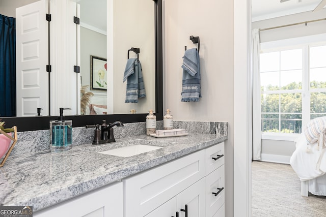 bathroom featuring crown molding, vanity, and baseboards