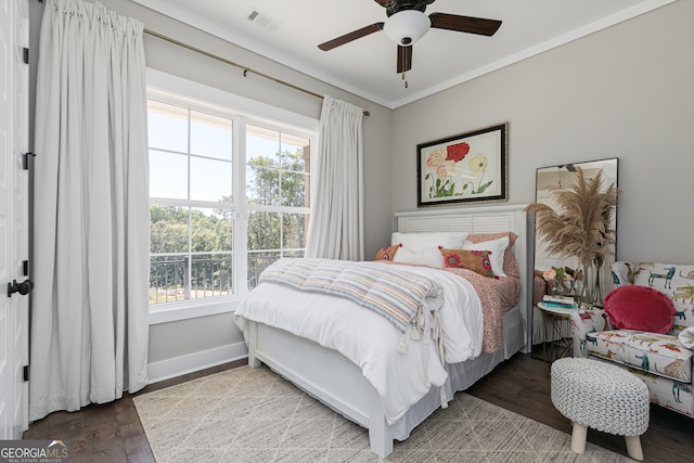 bedroom featuring wood finished floors, a ceiling fan, visible vents, baseboards, and ornamental molding