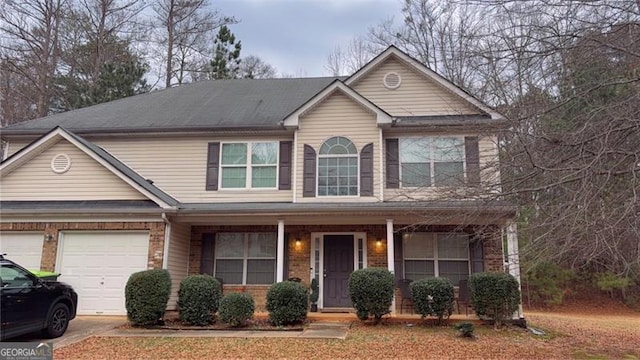 view of front of home with covered porch, concrete driveway, and brick siding