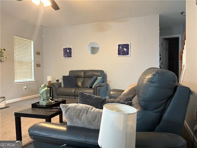 living area with a ceiling fan, carpet flooring, and baseboards